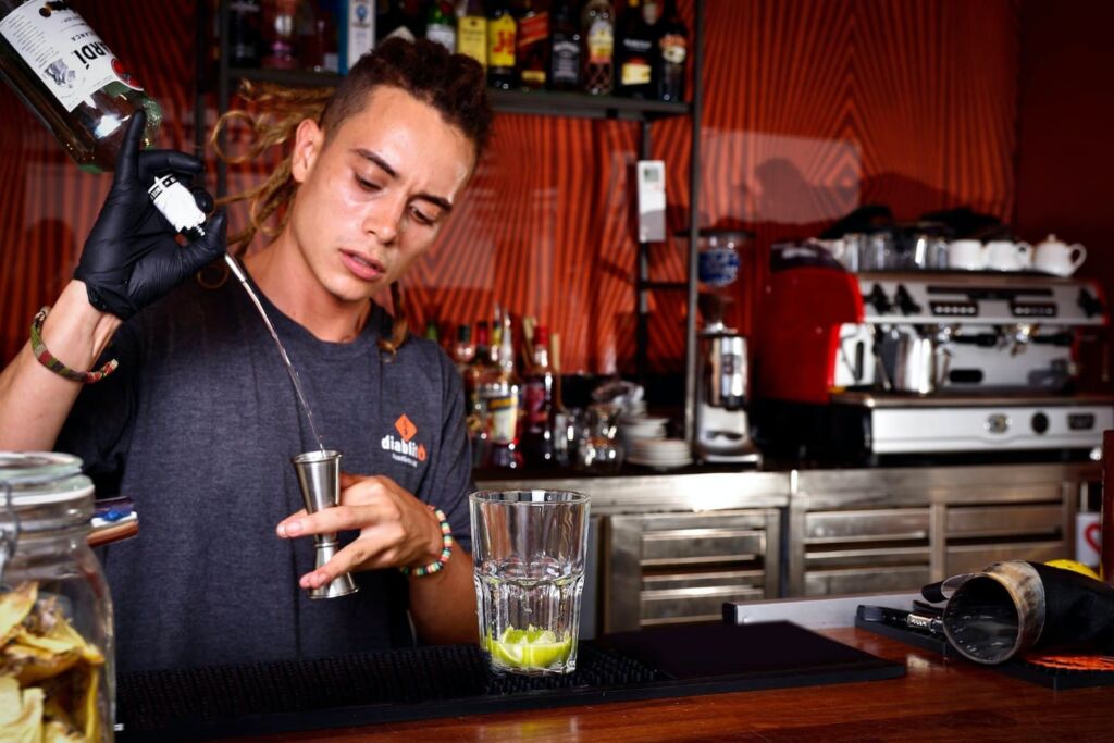a man is making a drink at a bar
